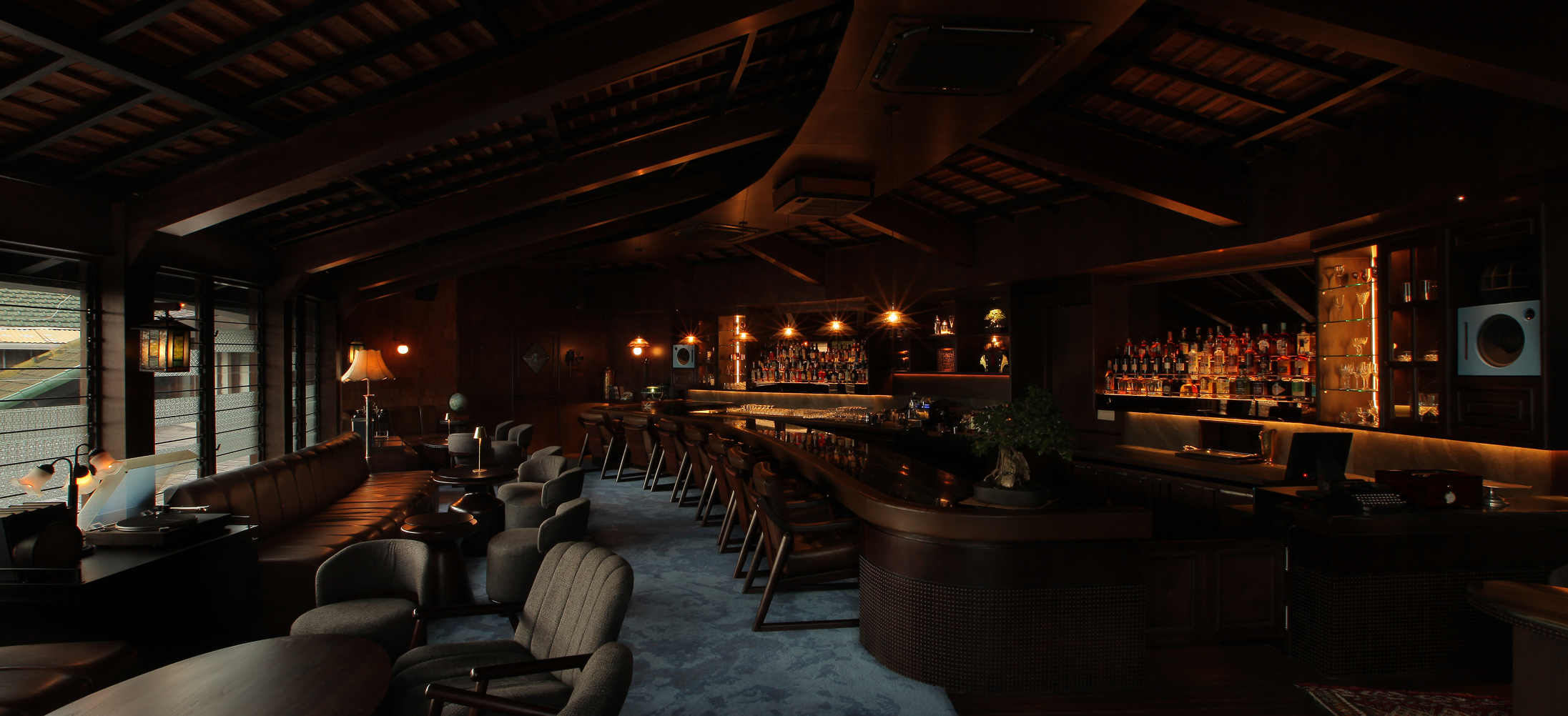 Aouku Japanese cocktail bar interior in Bali with elegant wooden bar and warm lighting