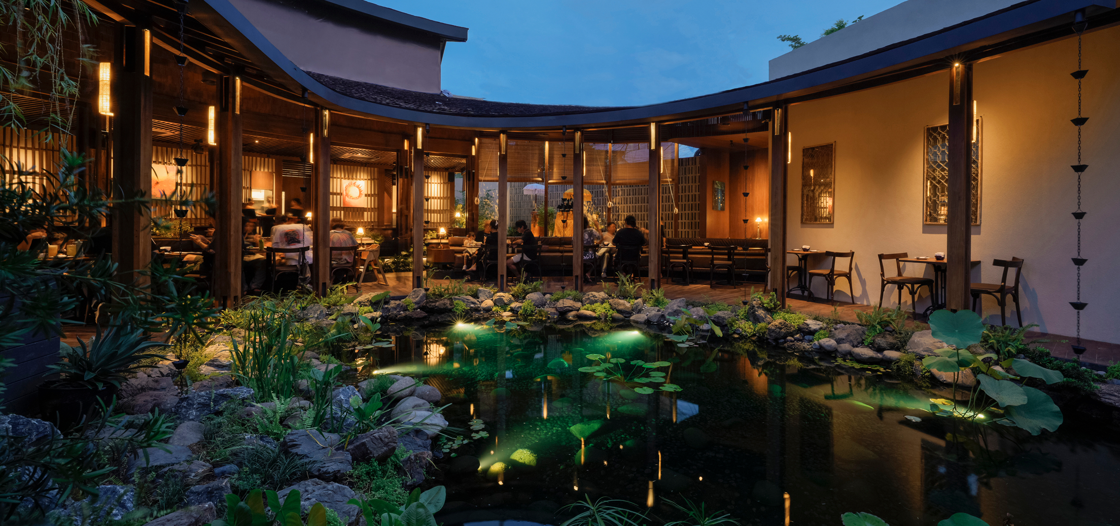 Dahana Japanese restaurant in Bali with serene garden pond and warm evening dining atmosphere