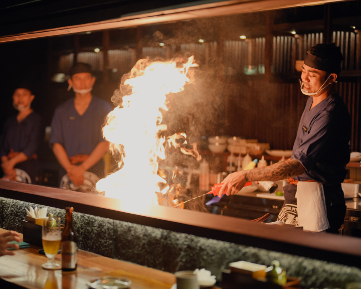 Teppanyaki chef performing live flame cooking at Rayjin Japanese restaurant Bali