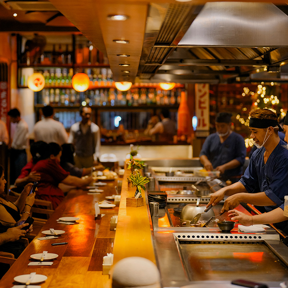 Guests enjoying live teppanyaki dining experience at Rayjin Bali